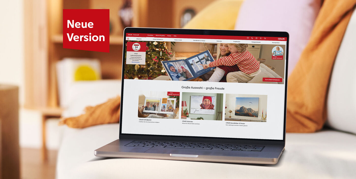 Laptop zeigt die CEWE Webseite mit Fotoprodukten in einem wohnlichen Raum